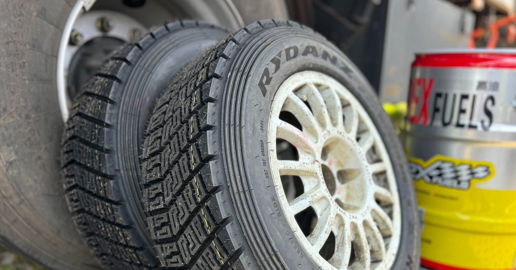 Närbild på rallydäck med grovt mönster monterat på en vit rallyfälg